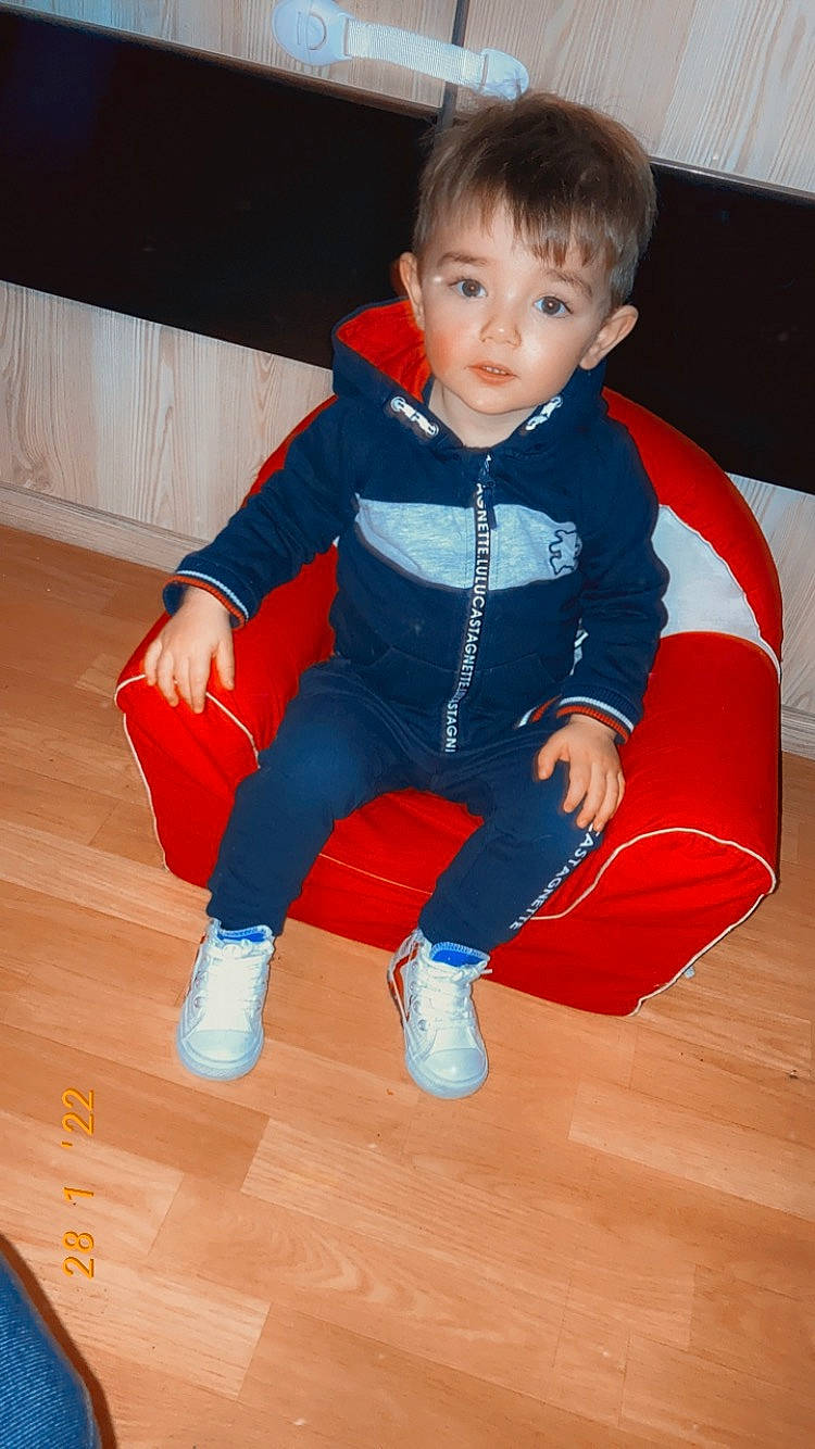 Emiliano a rejoint le concours — aidez-le/la à gagner de superbes lots ! baby_toddler_clothing, comfort, electric_blue, eye, face, finger, floor, flooring, fun, hardwood, head, human_leg, knee, orange, person, recreation, sitting, sleeve, thumb, toddler