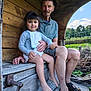Mia participe au concours pour gagner de l'argent avec cette photo : child, elderly_man, bench, wood, outdoor, nature, smiling, barefoot, bib, casual_clothing, greenery, sky, summer, portrait, family, holding, rustic, wooden_structure, relaxed, seated