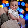 baby, child, smile, happy, person, holding, adult, arm, shorts, shirt, pattern, face, skin, head, background, bokeh, lights, colorful, blur, portrait