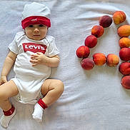 Joud joined the competition — help win amazing prizes! baby, infant, onesie, hat, levi's, peaches, fruit, blanket, white, cute, lying_down, socks, number, playful, soft, indoor, child, portrait, skin, looking
