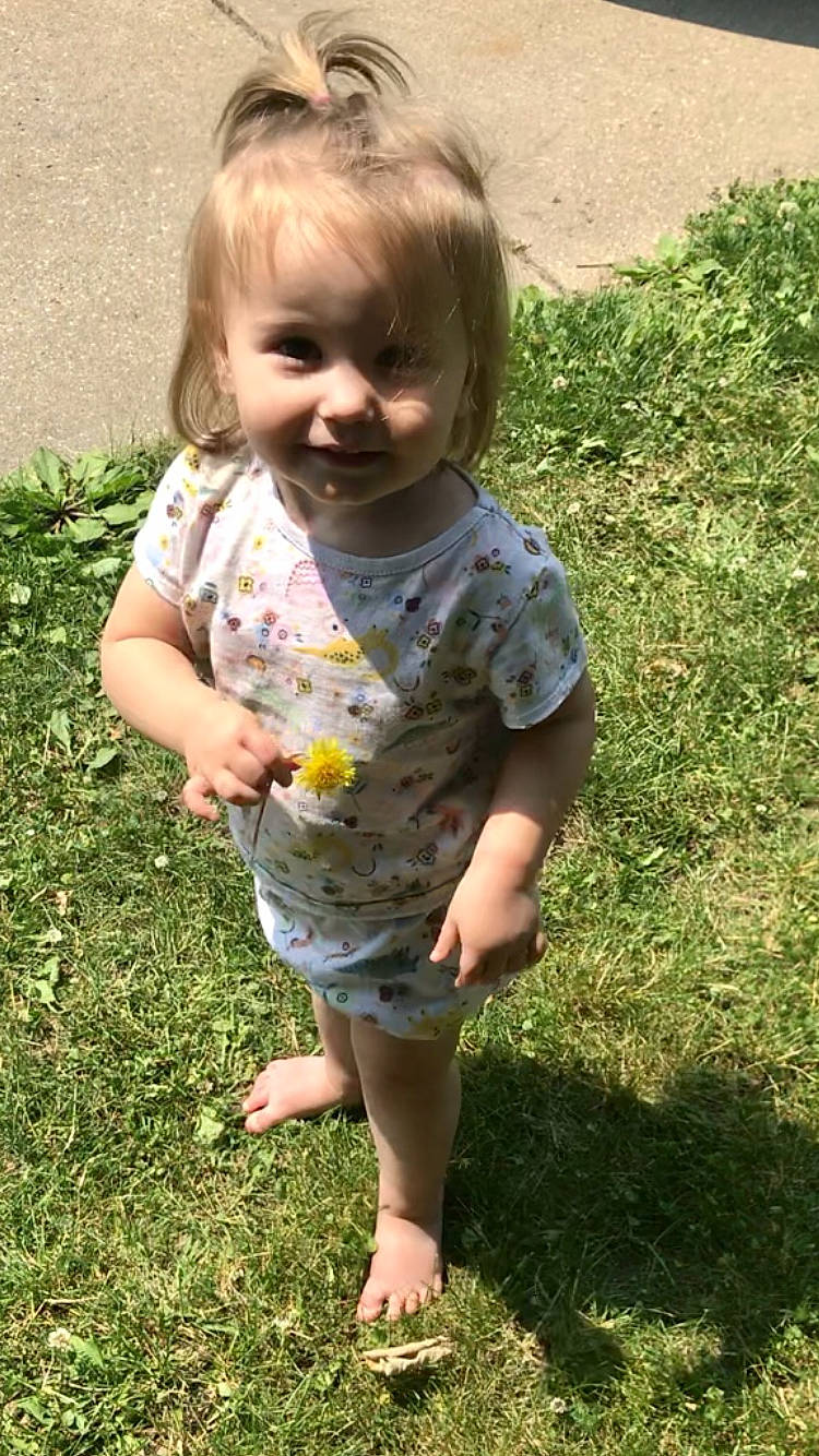 Ellie is registered to the contest to win money with this photo: baby, baby_toddler_clothing, barefoot, child, face, foot, fun, grass, grass_family, groundcover, hair, happy, head, joy, pattern, people_in_nature, person, plant, sleeve, smile