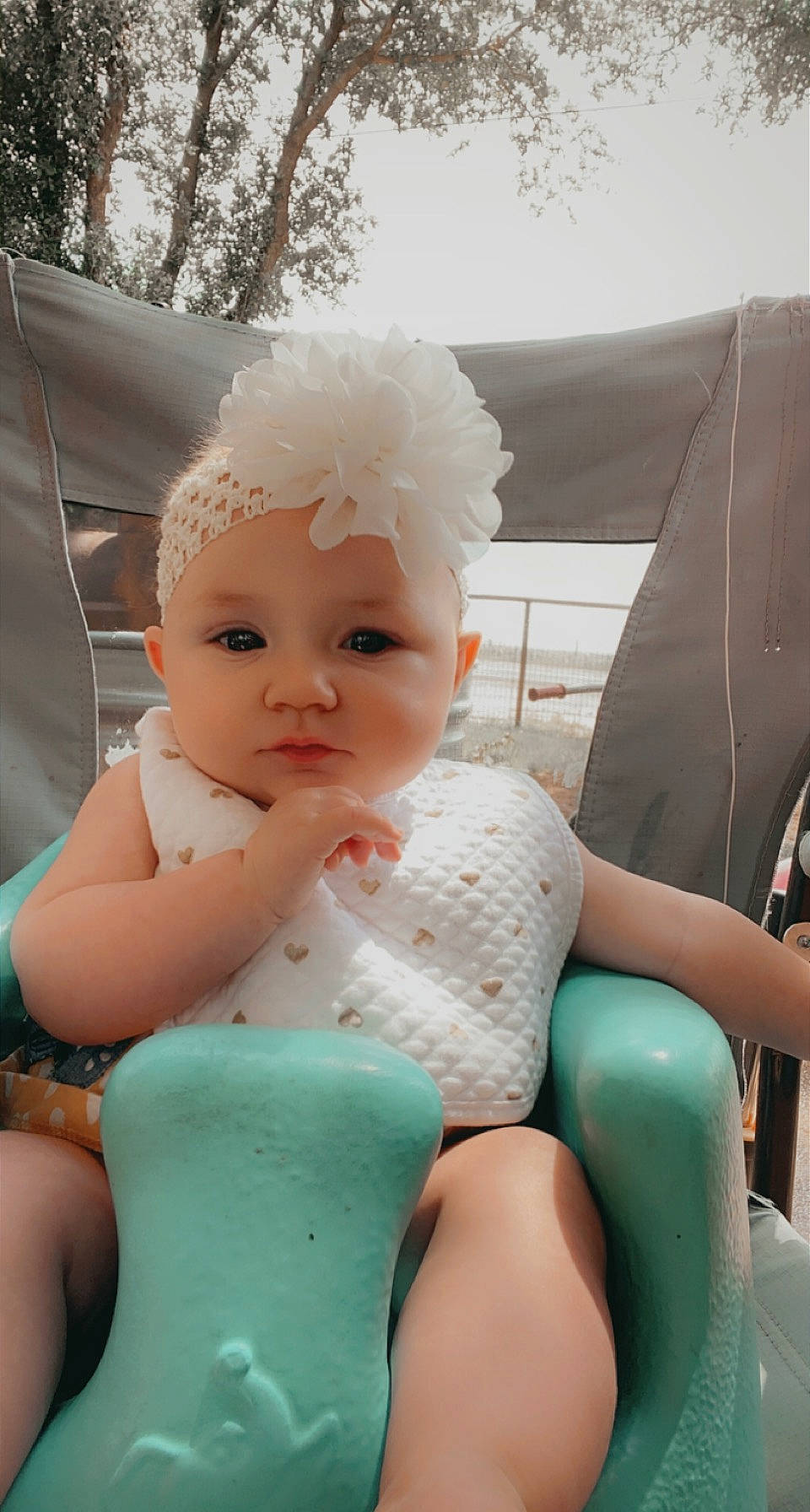 Amelia is registered to the contest to win money with this photo: abdomen, baby, baby_products, baby_toddler_clothing, cap, chest, dress, fashion_accessory, finger, happy, headgear, headwear, human_leg, jewellery, lip, nail, person, sitting, skin, thigh