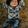 toddler, child, grass, barefoot, hat, cowboy_hat, jeans, patterned_shirt, smile, outdoor, nature, playful, dirt, happy, sitting, person, portrait, young_child, casual_clothing, daylight
