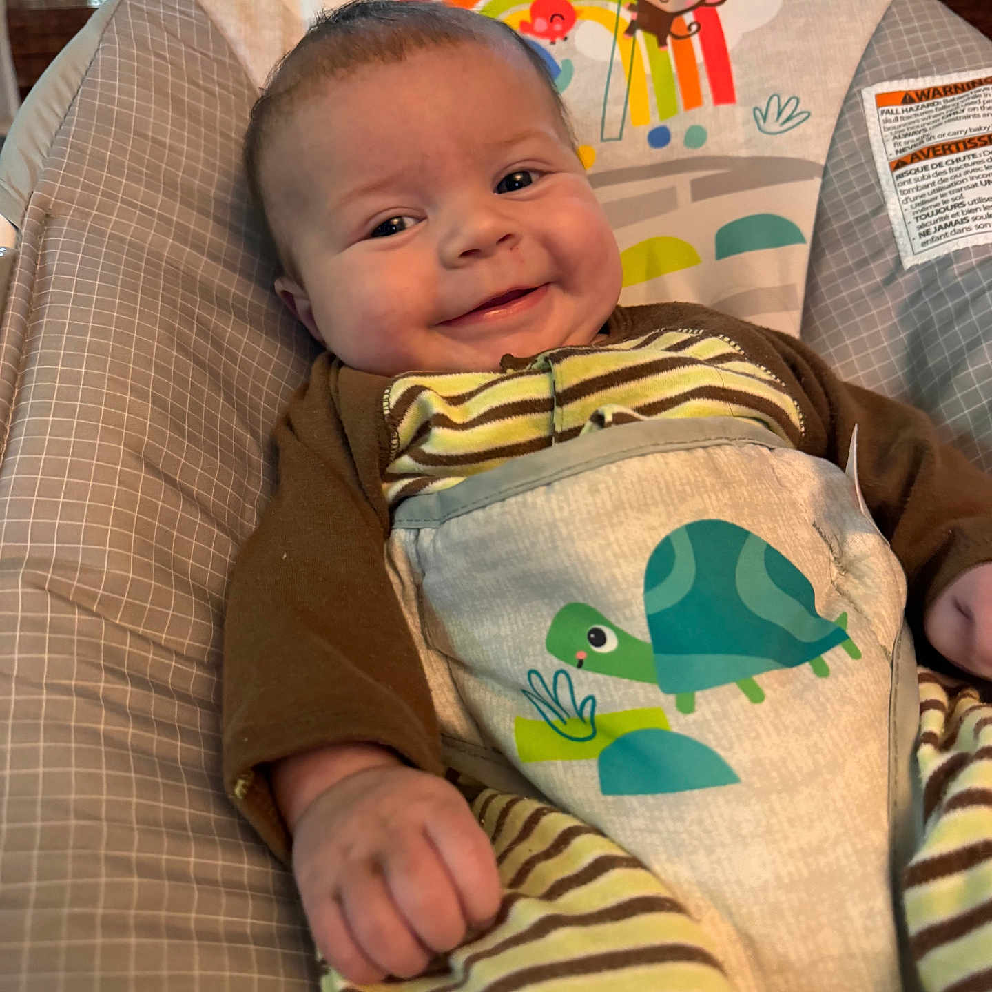 Theodore joined the competition — help win amazing prizes! baby, infant, child, smiling, portrait, sitting, bouncer, baby_seat, striped_clothing, turtle, animal_pattern, blanket, cushion, indoor, home, sunlight, window, bamboo_shades, happy, face