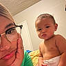 Emiliano joined the competition — help win amazing prizes! baby, child, woman, glasses, diaper, indoor, portrait, face, skin, hand, expression, towel, bedroom, person, casual, curly_hair, light, young_child, close_up, room