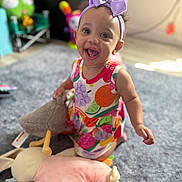 Waverly joined the competition — help win amazing prizes! baby, child, smiling, headband, bow, colorful_dress, plush_toy, carpet, indoor, happy, cute, playful, person, infant, toy, floor, room, childhood, fun, portrait