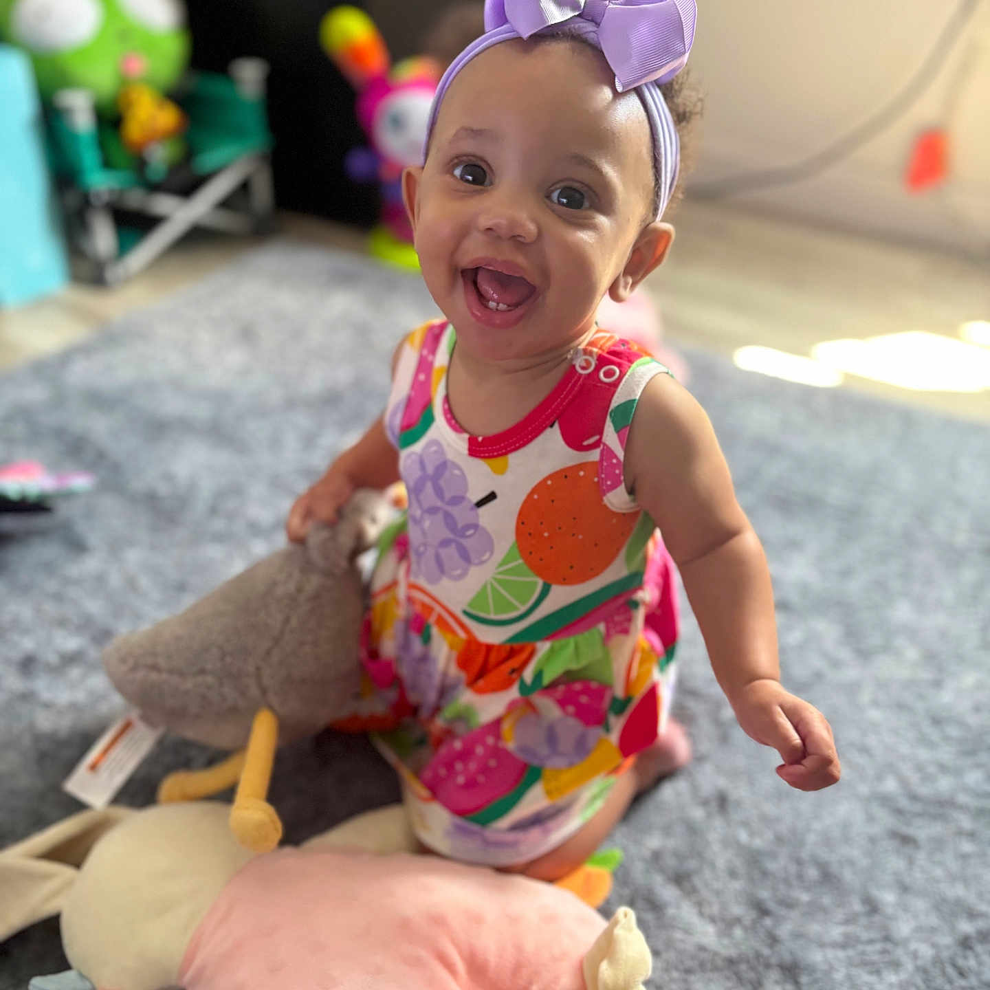 Waverly joined the competition — help win amazing prizes! baby, child, smiling, headband, bow, colorful_dress, plush_toy, carpet, indoor, happy, cute, playful, person, infant, toy, floor, room, childhood, fun, portrait