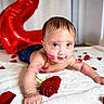 Cesar is registered to the contest to win money with this photo: baby, infant, red_rose, rose_petals, balloon, number_two, lipstick_marks, blue_eyes, blanket, cute, child, lying_down, bracelet, indoor, portrait, celebration, playful, skin, face, smile