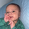 Cesar joined the competition — help win amazing prizes! baby, infant, green_clothing, dinosaur_pattern, hand_gesture, face, portrait, cute, lying_down, quilted_surface, blue_background, child, young, sleepwear, indoor, expression, human, skin, eyes, mouth