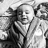 adorable, baby, bathrobe, bedding, blanket, cheeks, cozy, face, happy, indoor, infant, infant_clothing, lying_down, monochrome, plush_toy, portrait, robe, smiling, toy, young_child