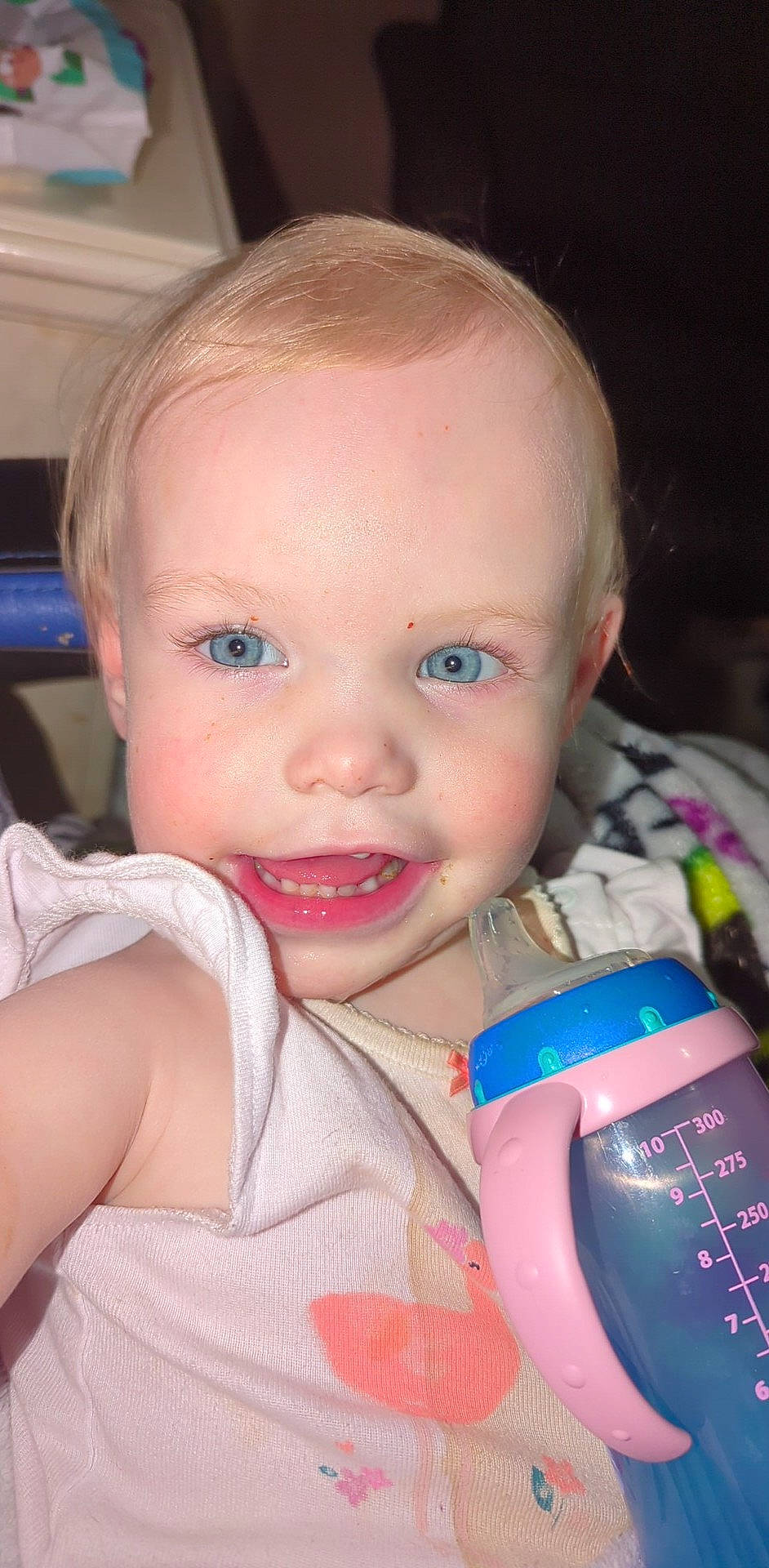 Evie is registered to the contest to win money with this photo: baby, baby_toddler_clothing, cheek, drinkware, ear, eyelash, finger, fun, gesture, happy, human, iris, lip, mouth, nail, nose, person, plastic_bottle, skin, smile