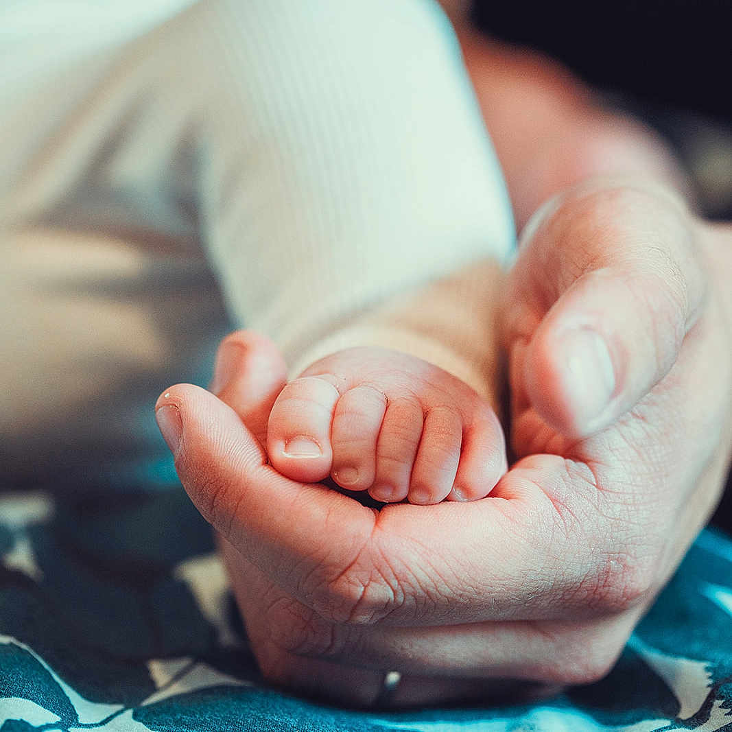 Giu a rejoint le concours — aidez-le/la à gagner de superbes lots ! adult_hand, baby, blue, care, close_up, cute, family, foot, hand, holding, infant, love, patterned_fabric, protection, skin, small, soft, tender, texture, white