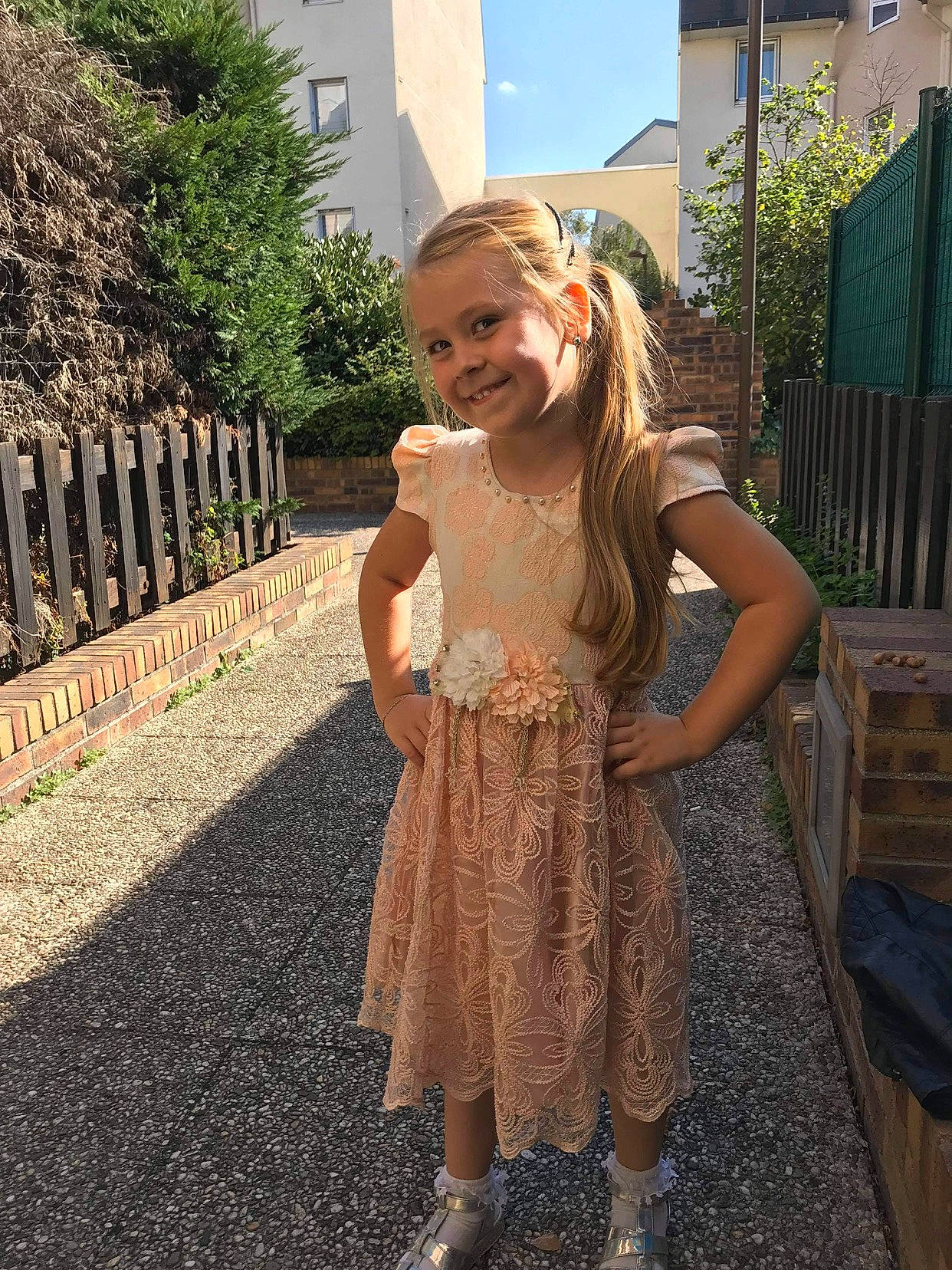 Leila a rejoint le concours — aidez-le/la à gagner de superbes lots ! baby_toddler_clothing, backyard, day_dress, dress, driveway, embellishment, home_fencing, joy, one_piece_garment, person, residential_area, summer, toddler, yard