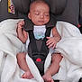 baby, car_seat, sleeping, blanket, infant, child, safety_harness, pacifier, clothing, cute, peaceful, indoors, head_support, footwearless, resting, soft_texture, comfort, seat, baby_carrier, newborn