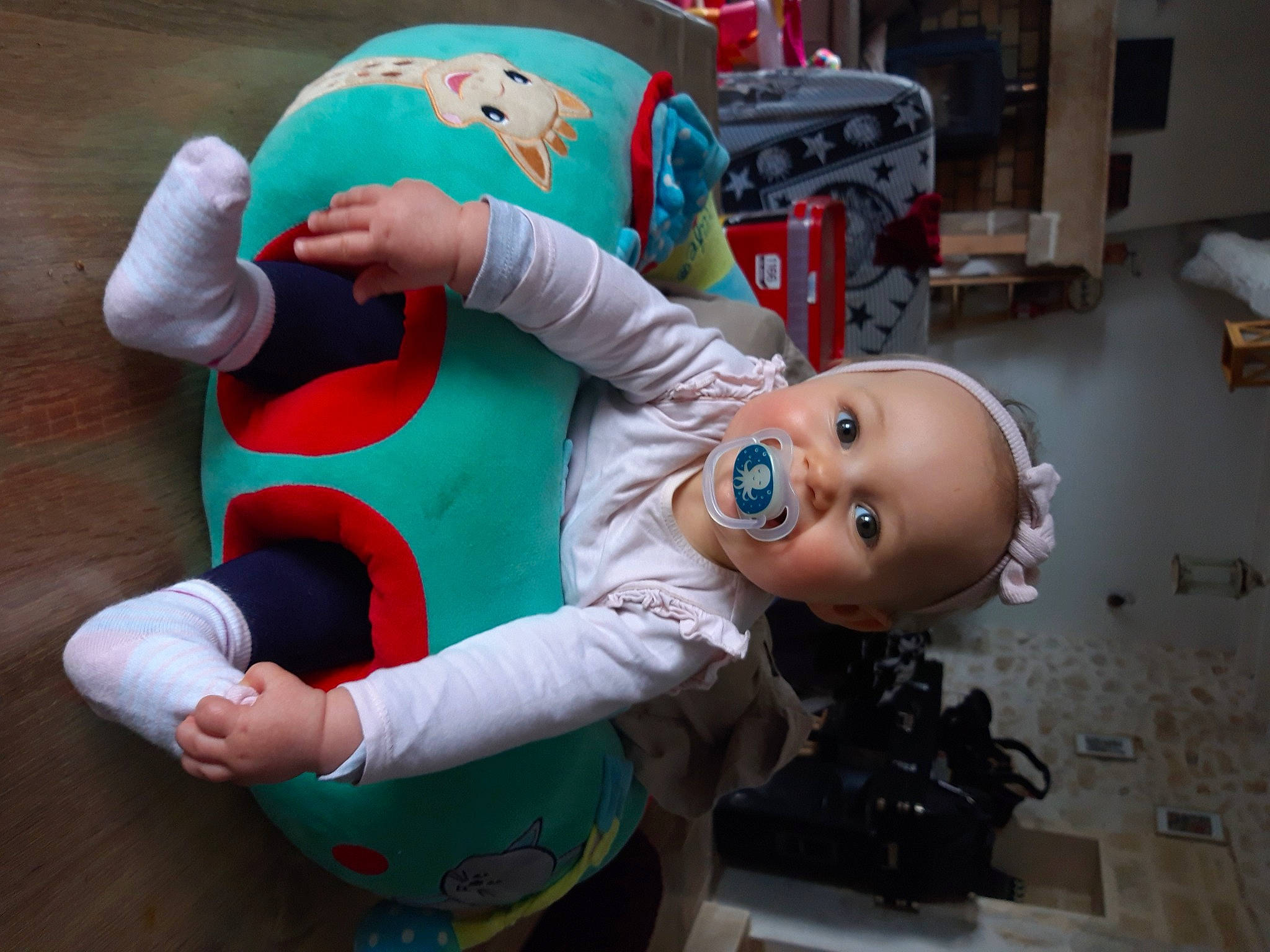 Lou participe au concours pour gagner de l'argent avec cette photo : animation, baby_toys, carmine, child, costume, doll, event, fictional_character, fun, gesture, happy, human_leg, knee, lap, person, room, sitting, smile, sock, stuffed_toy