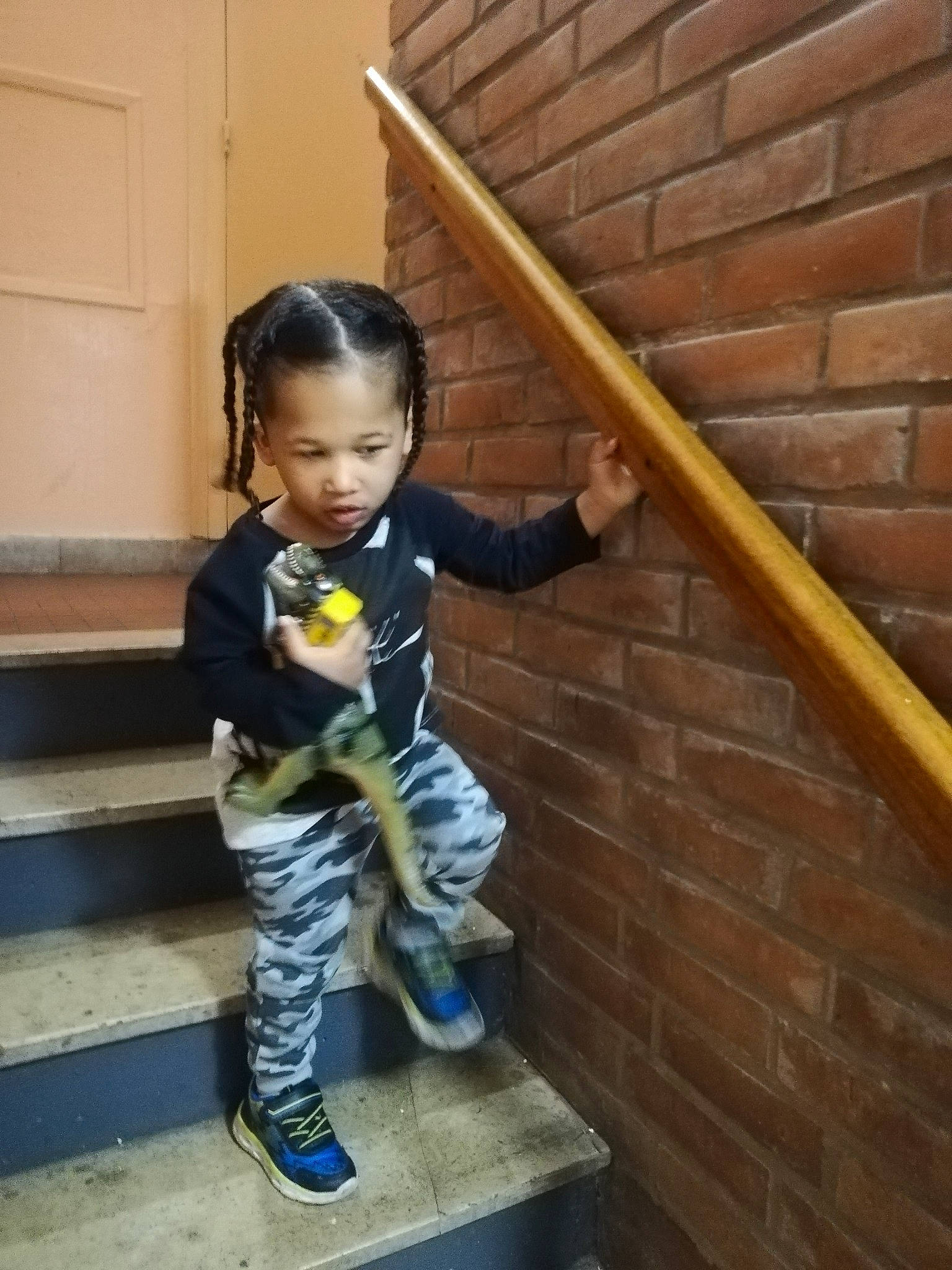 Djenaël participe au concours pour gagner de l'argent avec cette photo : baby_toddler_clothing, boot, brick, brickwork, child, door, flooring, hardwood, human_leg, knee, pattern, person, sitting, sleeve, stairs, standing, thigh, toddler, wood