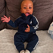 Taige joined the competition — help win amazing prizes! toddler, child, baby, adidas, tracksuit, socks, couch, sofa, indoor, person, young_child, expression, seated, home, clothing, cute, comfortable, smiling, hand_gesture, face