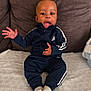 toddler, child, baby, adidas, tracksuit, socks, couch, sofa, indoor, person, young_child, expression, seated, home, clothing, cute, comfortable, smiling, hand_gesture, face