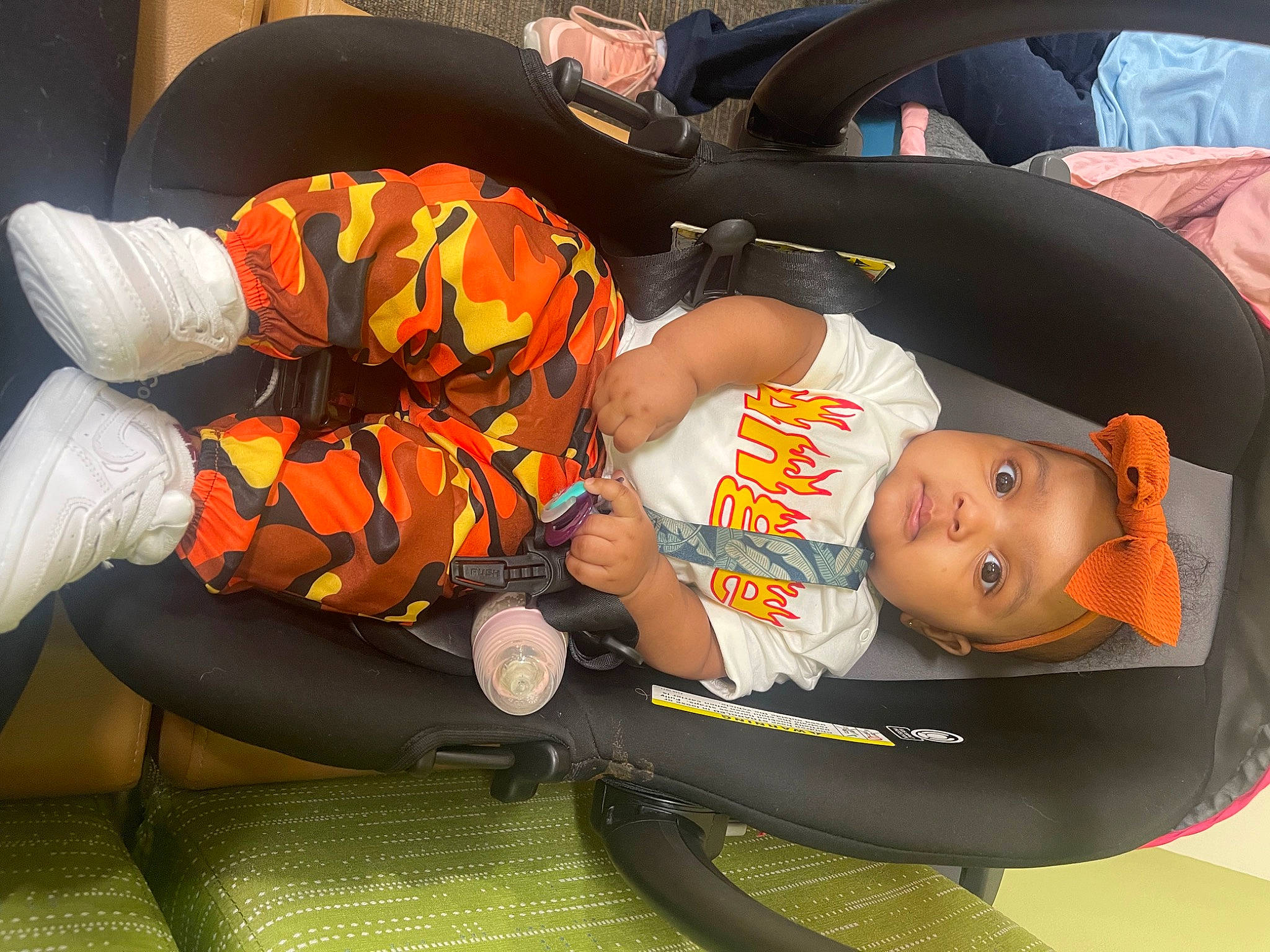 Paitence is registered to the contest to win money with this photo: baby, baby_carriage, baby_products, baby_safety, baby_toddler_clothing, car_seat, child, comfort, fun, headwear, knee, lap, orange, person, room, sitting, thigh, toddler