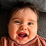 baby, infant, smiling, laugh, eyes, eyelashes, teeth, mouth_open, chubby_cheeks, close_up, face, hair, tousled_hair, couch, pillow, clothing, portrait, joyful, happy, natural_light