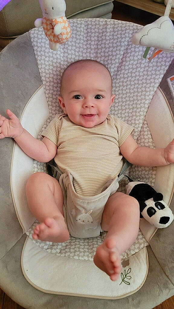 Carter is registered to the contest to win money with this photo: baby, baby_toddler_clothing, cheek, child, comfort, eye, finger, foot, happy, human_leg, joy, organ, person, pink, product, sitting, skin, sleeve, smile, thigh