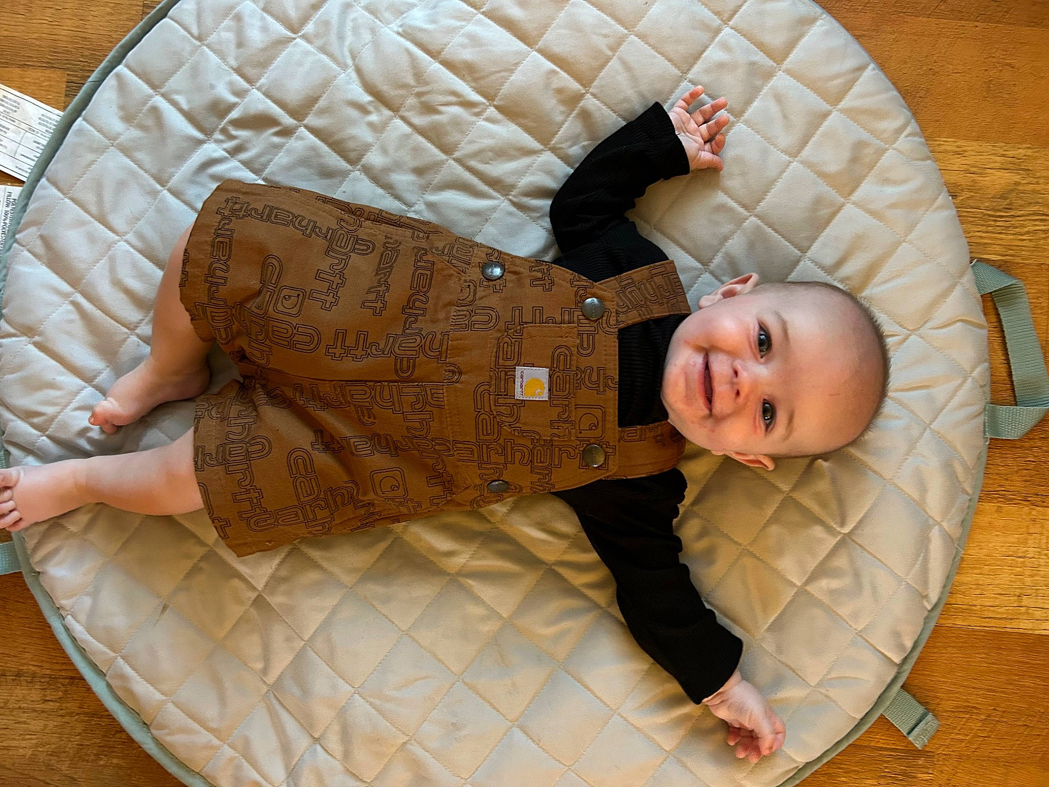 Carter is registered to the contest to win money with this photo: baby, baby_products, baby_safety, baby_toddler_clothing, child, comfort, flooring, hardwood, head, human_body, infant_bed, joy, linens, pattern, person, room, sitting, sleeve, smile, textile
