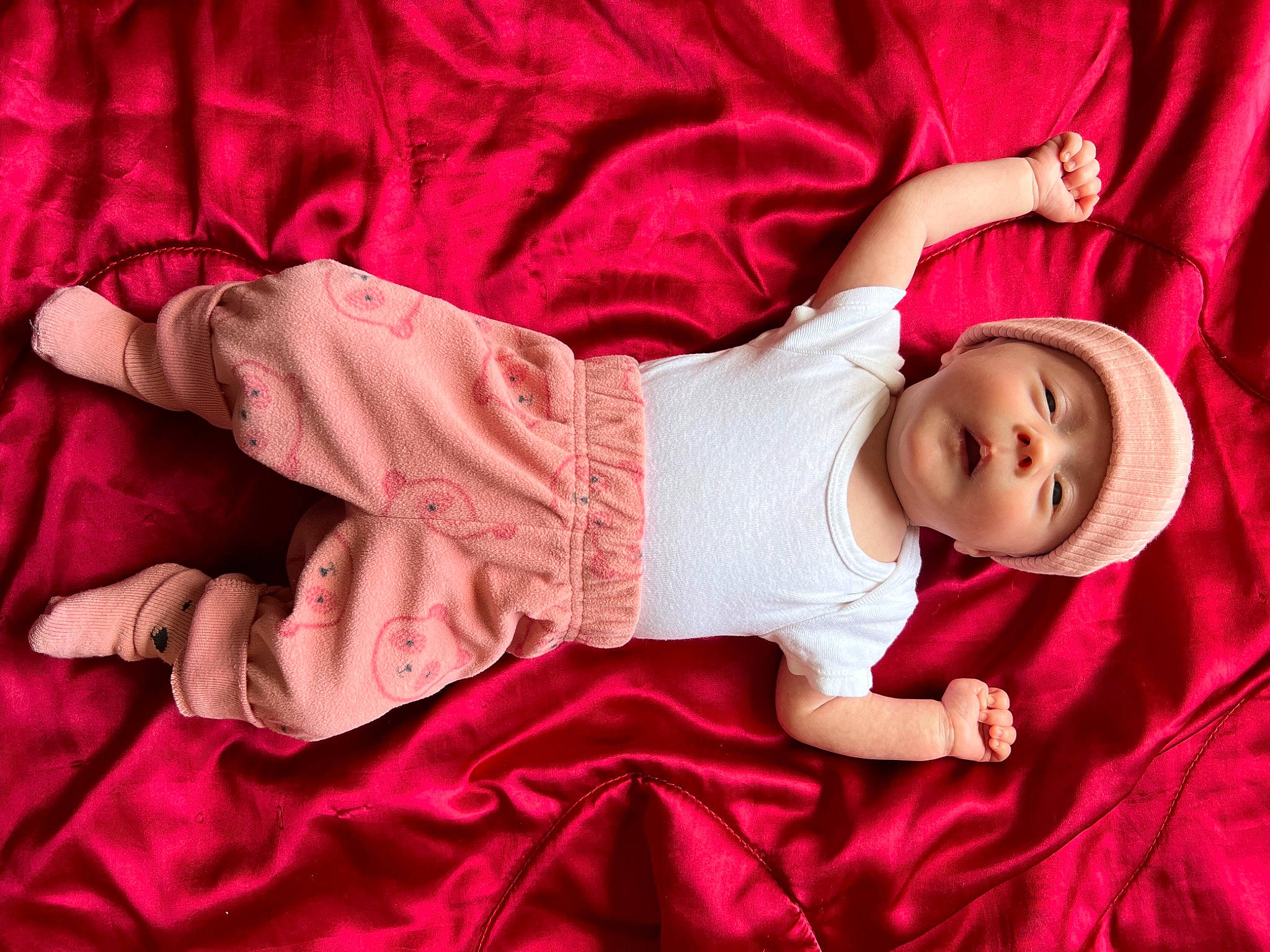 Blair is registered to the contest to win money with this photo: baby, baby_toddler_clothing, child, comfort, elbow, headwear, human_body, human_leg, joint, linens, magenta, pattern, person, pink, purple, room, skin, sleeve, smile, t_shirt