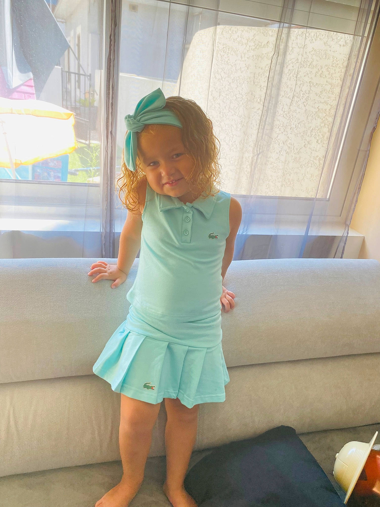 Taïsana a rejoint le concours — aidez-le/la à gagner de superbes lots ! barefoot, blond, child, comfort, dress, elbow, flooring, foot, fun, happy, headwear, human_body, human_leg, joy, knee, leg, leisure, person, room, thigh