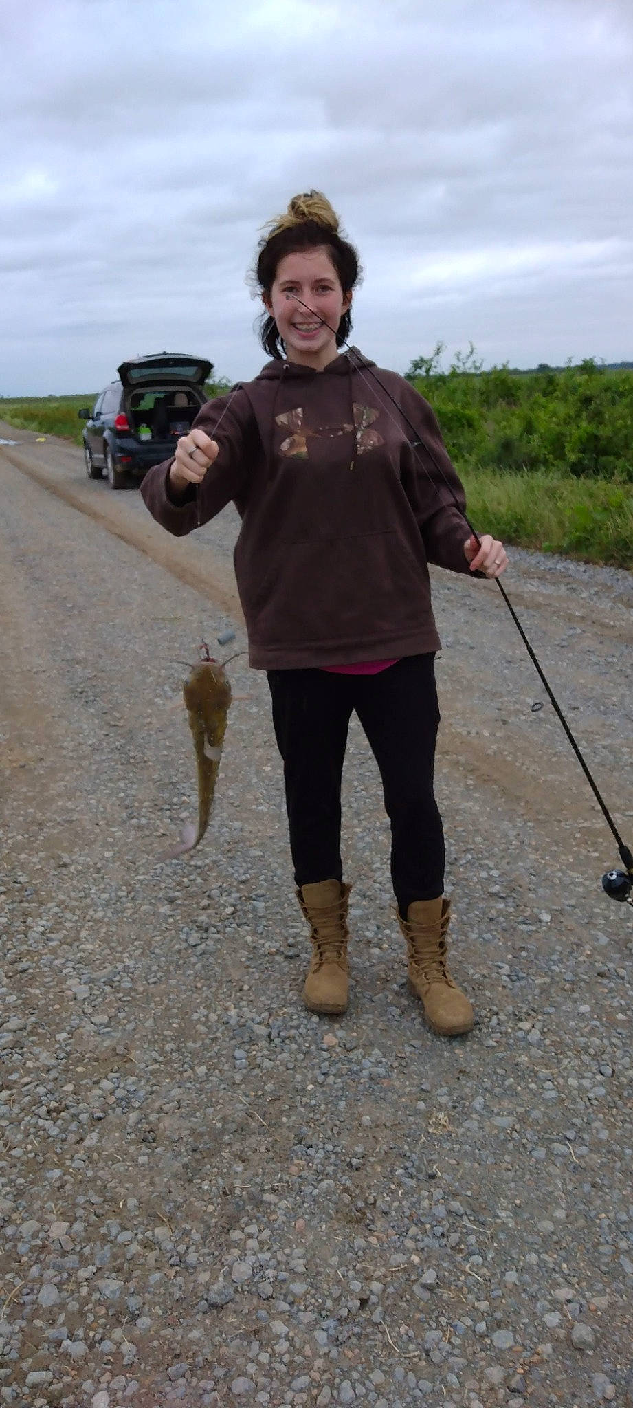 Jaden is registered to the contest to win money with this photo: asphalt, boot, grass, grassland, human_leg, joy, knee, landscape, leg, people_in_nature, person, recreation, road, sandal, shoe, sky, smile, sneakers, soil, travel