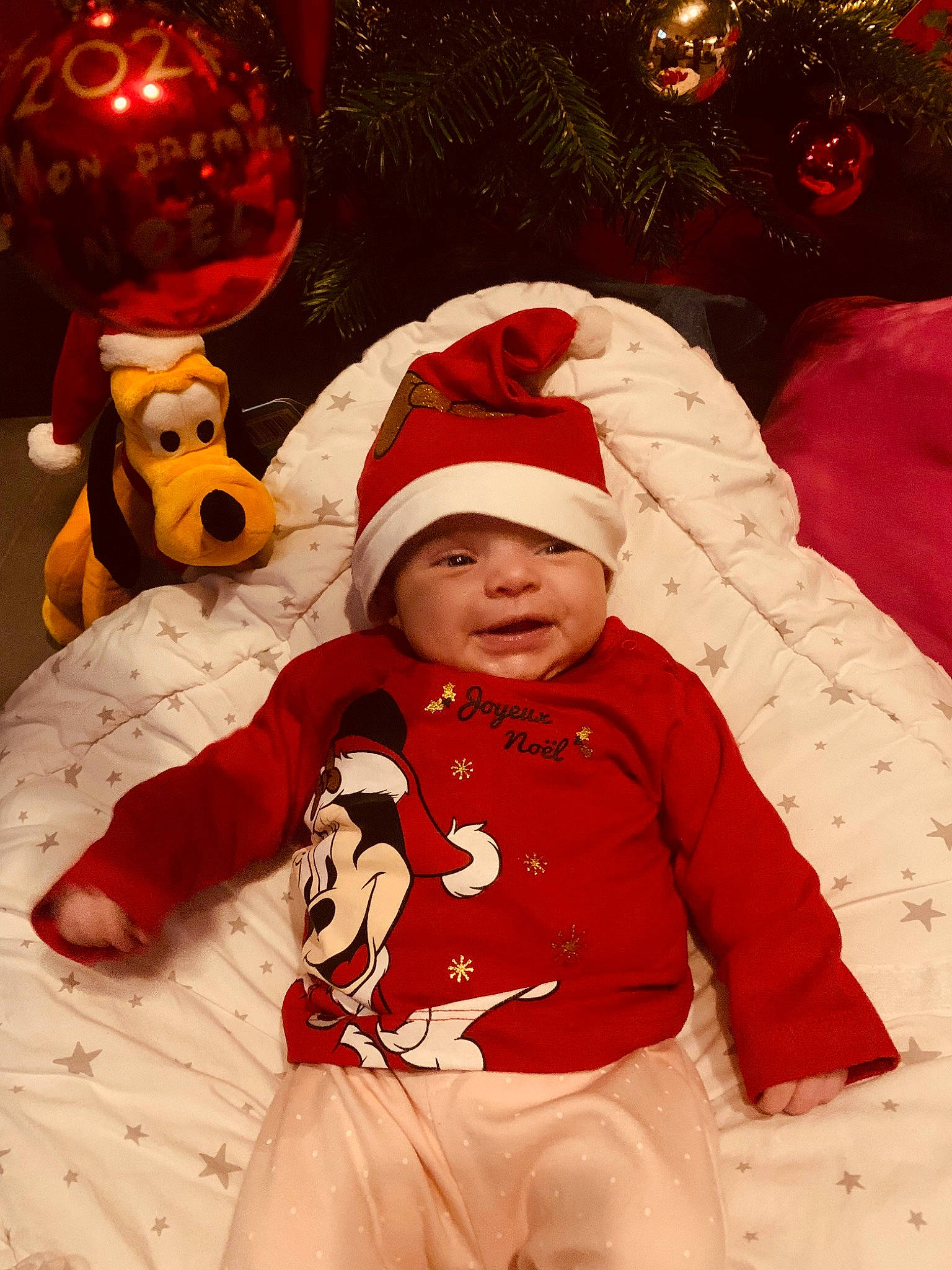 Mya participe au concours pour gagner de l'argent avec cette photo : baby, baby_toddler_clothing, child, christmas, christmas_decoration, christmas_eve, christmas_ornament, event, fictional_character, fun, happy, headwear, holiday, ornament, outerwear, people, person, red, santa_claus, sleeve