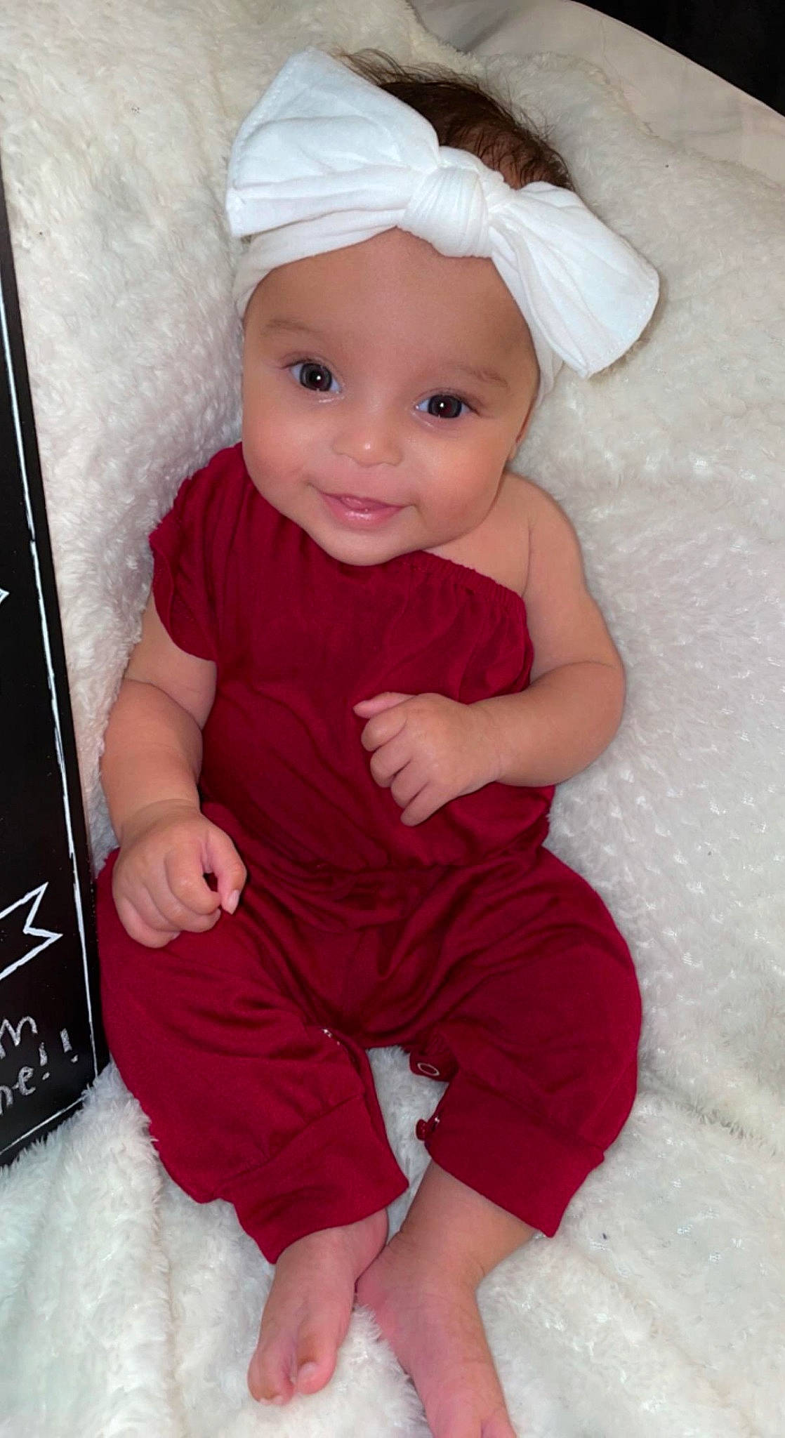 Avani is registered to the contest to win money with this photo: arm, baby_toddler_clothing, cap, cheek, chin, clothing, eye, gesture, hand, head, headwear, human_body, lip, person, pink, product, skin, sleeve, smile, standing