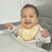 Imran participe au concours pour gagner de l'argent avec cette photo : baby, high_chair, bib, food, messy, smiling, drool, indoor, child, cute, happy, winnie_the_pooh, clothing, person, face, table, feeding, infant, young_child, hand