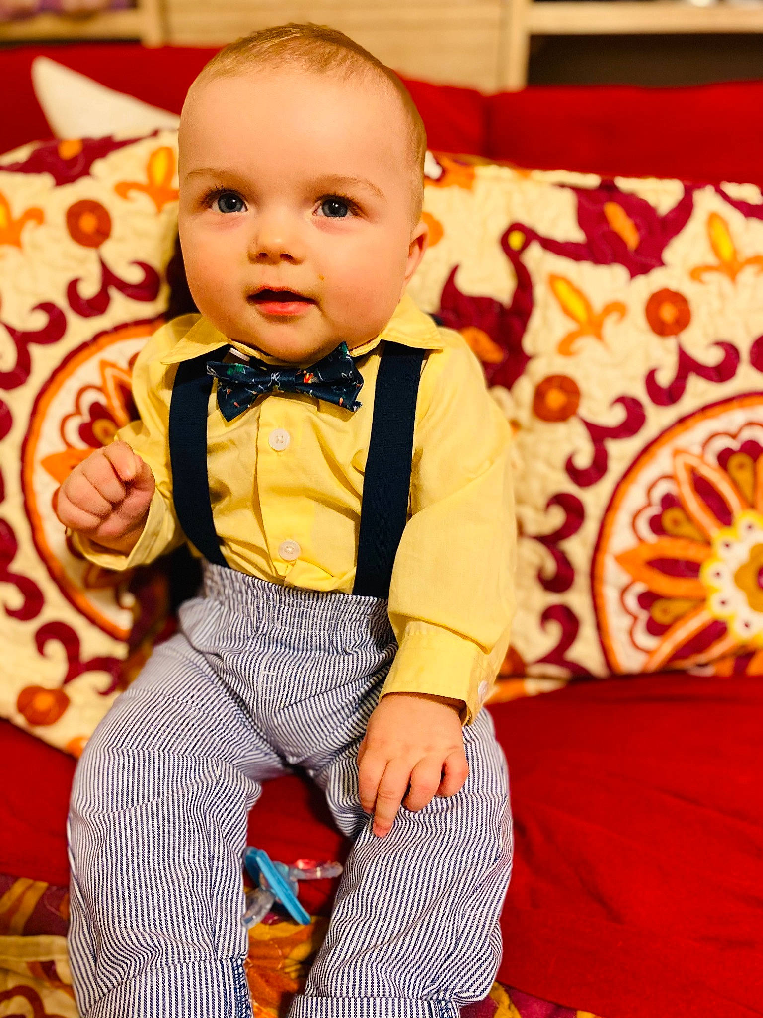 Justin Bradley is registered to the contest to win money with this photo: baby, baby_toddler_clothing, bow_tie, child, couch, event, fashion, formal_wear, fun, happy, orange, outerwear, pattern, person, room, sitting, sleeve, suit, tie, toddler