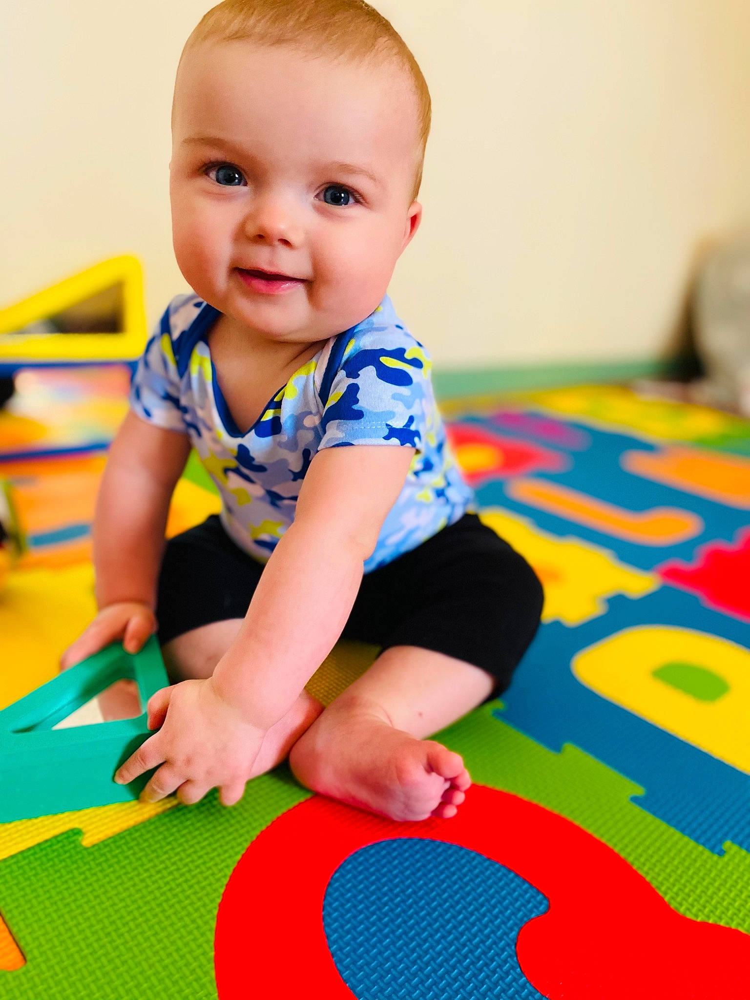 Justin Bradley is registered to the contest to win money with this photo: arm, baby, baby_playing_with_toys, baby_toddler_clothing, child, electric_blue, facial_expression, floor, flooring, fun, happy, leisure, people_in_nature, person, product, skin, sleeve, smile, standing, t_shirt