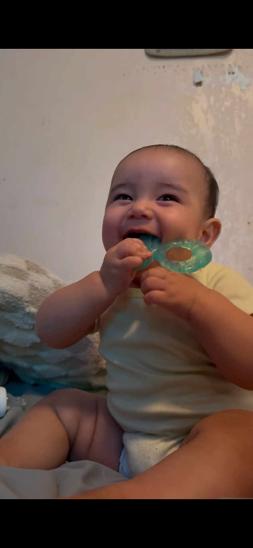 Kaitoa is registered to the contest to win money with this photo: baby, teething_toy, smiling, indoor, child, infant, happy, cute, person, sitting, blanket, skin, face, hand, mouth, toy, young, one_person, casual, relaxed