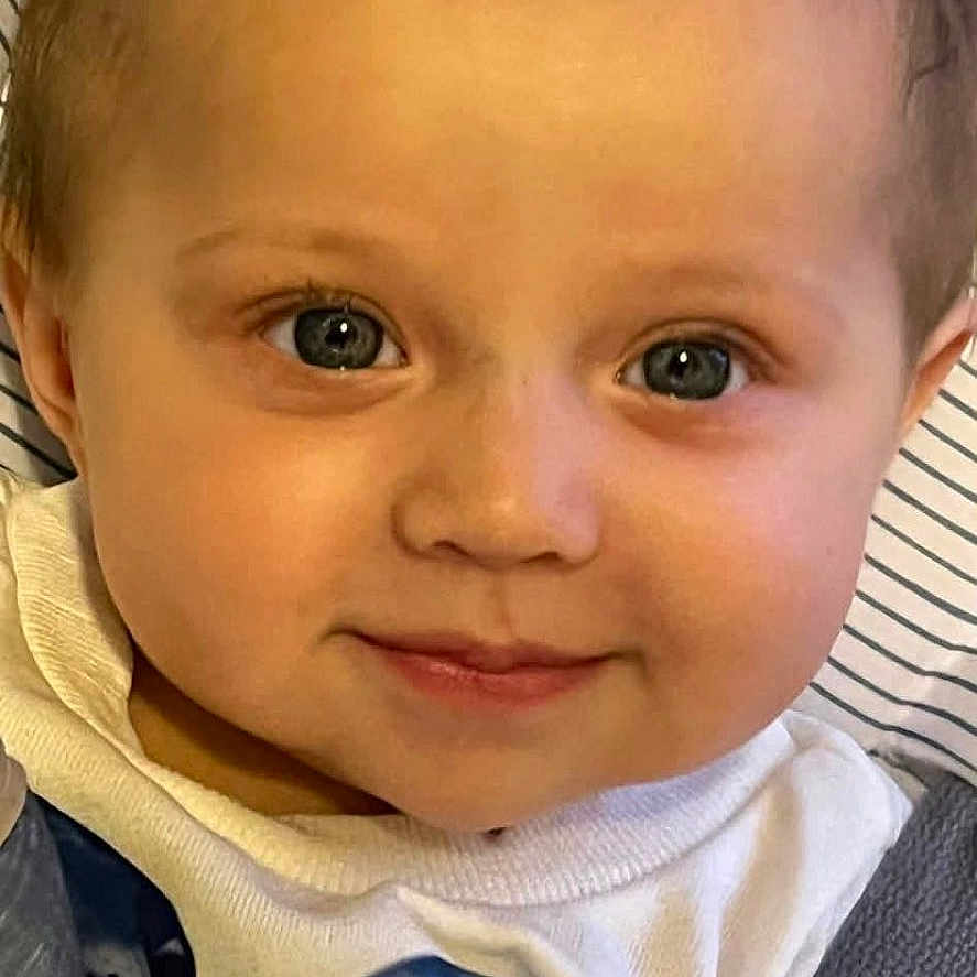 Naeomi joined the competition — help win amazing prizes! baby, child, face, smile, bow, hair_accessory, white_shirt, blue_bow, car_seat, seatbelt, infant, portrait, cute, young_child, indoor, person, clothing, head, eyes, skin