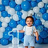 toddler, child, birthday, balloons, blue, white, crown, suspenders, shorts, happy, smiling, barefoot, number_one, celebration, party, indoor, portrait, decorations, glowing, floor