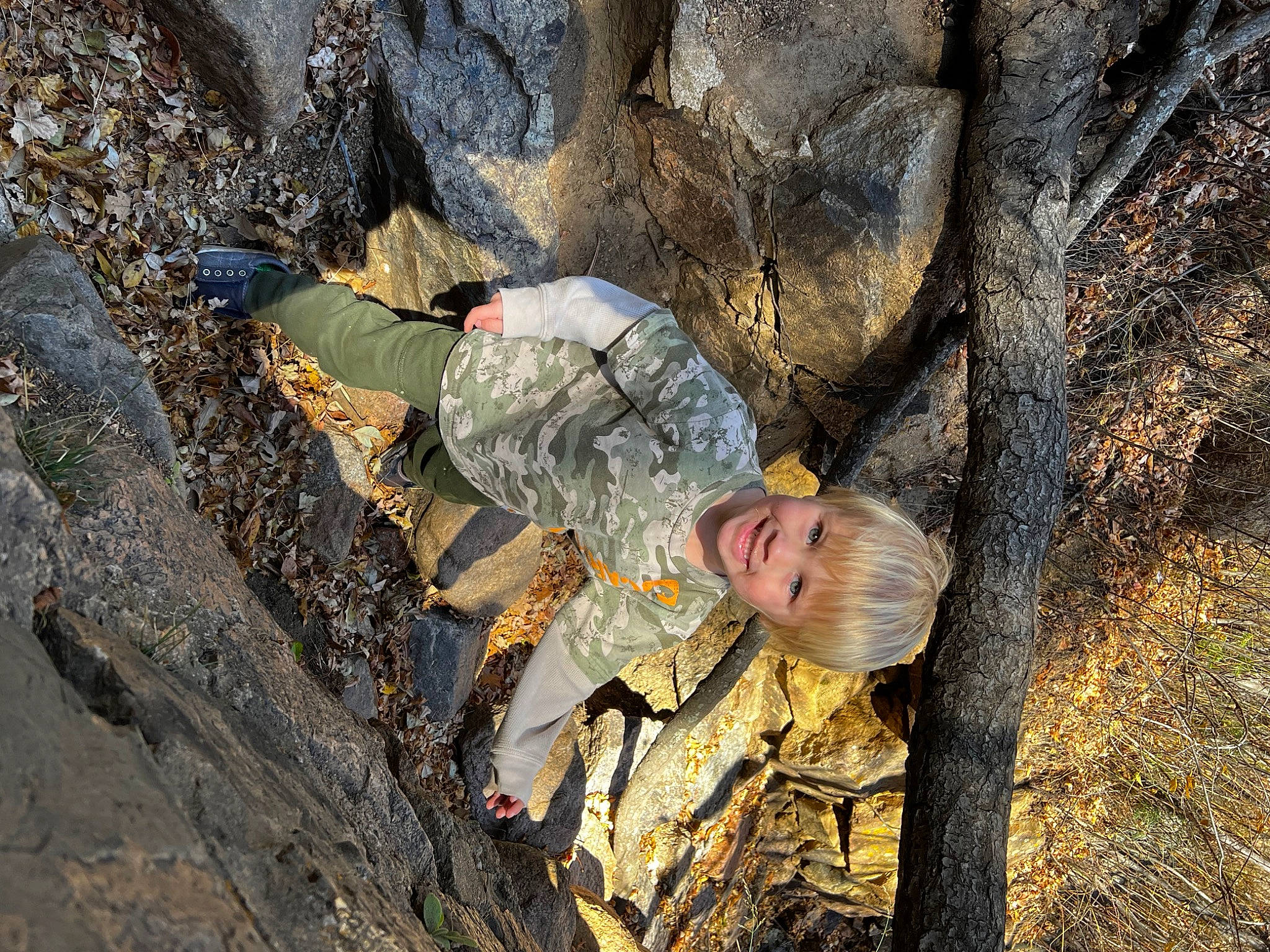 Ben is registered to the contest to win money with this photo: adventure, army, bedrock, camouflage, helmet, infantry, joy, marines, military_camouflage, military_organization, military_person, military_uniform, people_in_nature, person, recreation, rock, soil, soldier, tree, trunk