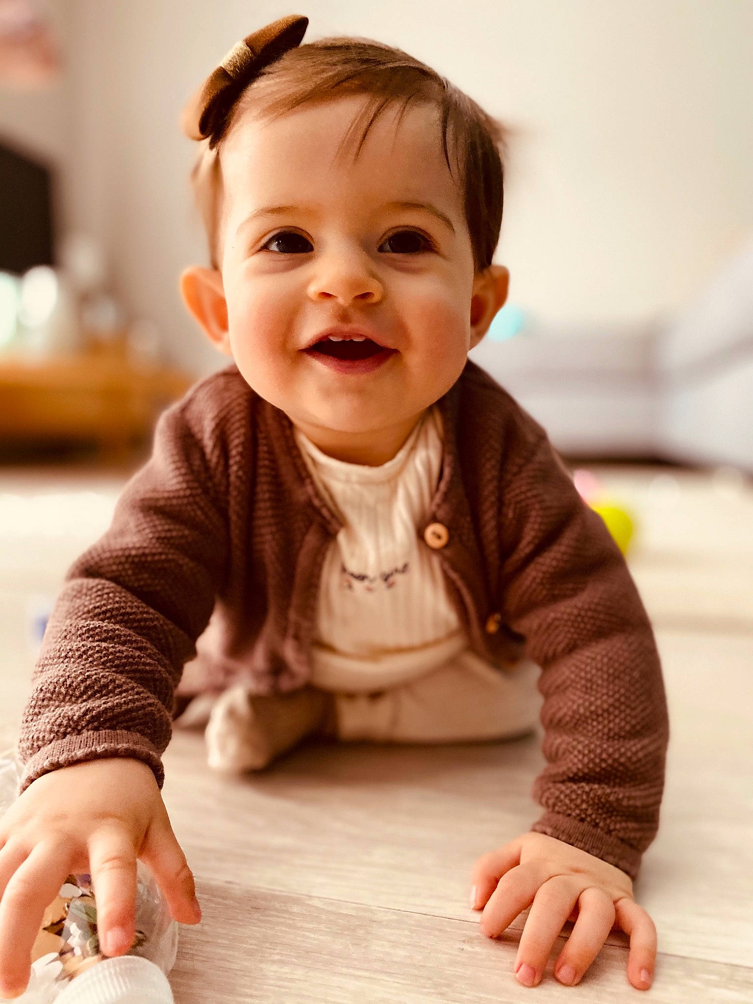 Ela participe au concours pour gagner de l'argent avec cette photo : arm, baby, baby_toddler_clothing, cheek, chin, dress, face, finger, floor, flooring, happy, hardwood, iris, joy, nose, person, skin, sleeve, smile, standing