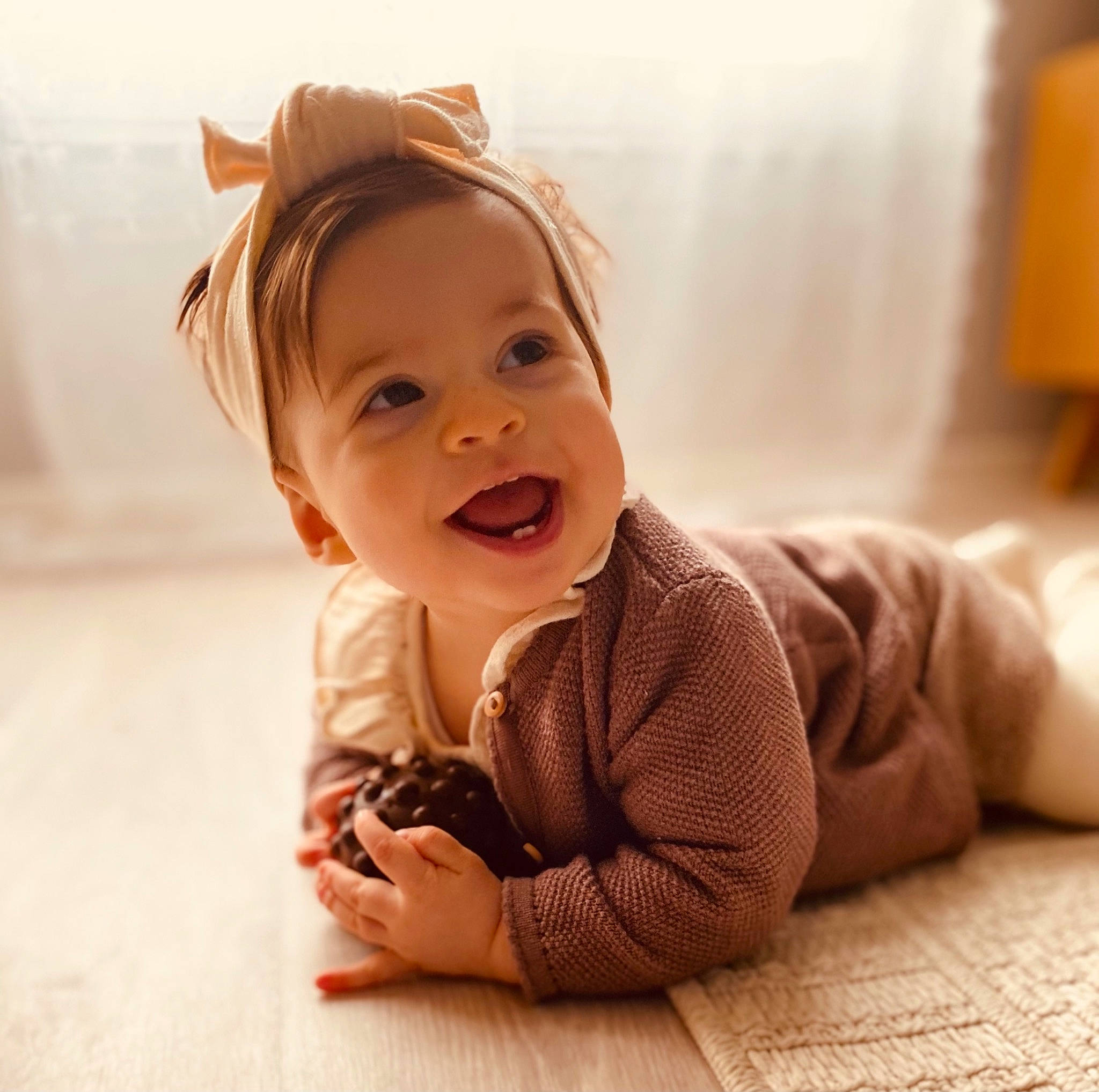 Ela participe au concours pour gagner de l'argent avec cette photo : baby, baby_toddler_clothing, cheek, child, comfort, dress, finger, floor, flooring, fun, hand, happy, hardwood, nose, person, sitting, skin, sleeve, smile, toddler