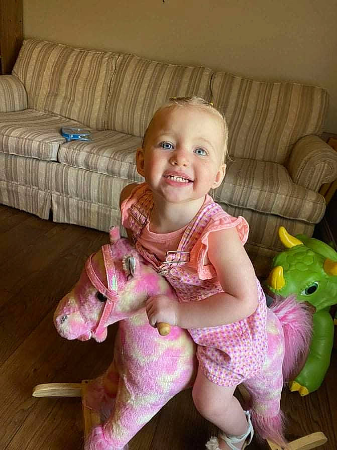 Jocelyn is registered to the contest to win money with this photo: baby, baby_toddler_clothing, comfort, couch, eye, flooring, happy, head, human_leg, iris, joy, knee, lap, leg, magenta, person, pink, skin, smile, sock