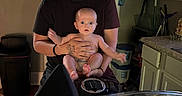 Elijah joined the competition — help win amazing prizes! baby, child, person, smile, kitchen, motorcycle, handlebars, windshield, indoor, cabinet, countertop, door, trash_can, light_switch, tattoo, short_sleeve_shirt, floor, expression, holding, curtain