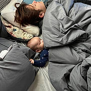 Elijah joined the competition — help win amazing prizes! baby, child, person, sleeping, bed, blanket, pillow, indoor, rest, cozy, hand_holding, nap, comfort, family, blanket_fold, head, hair, clothing, peaceful, quiet