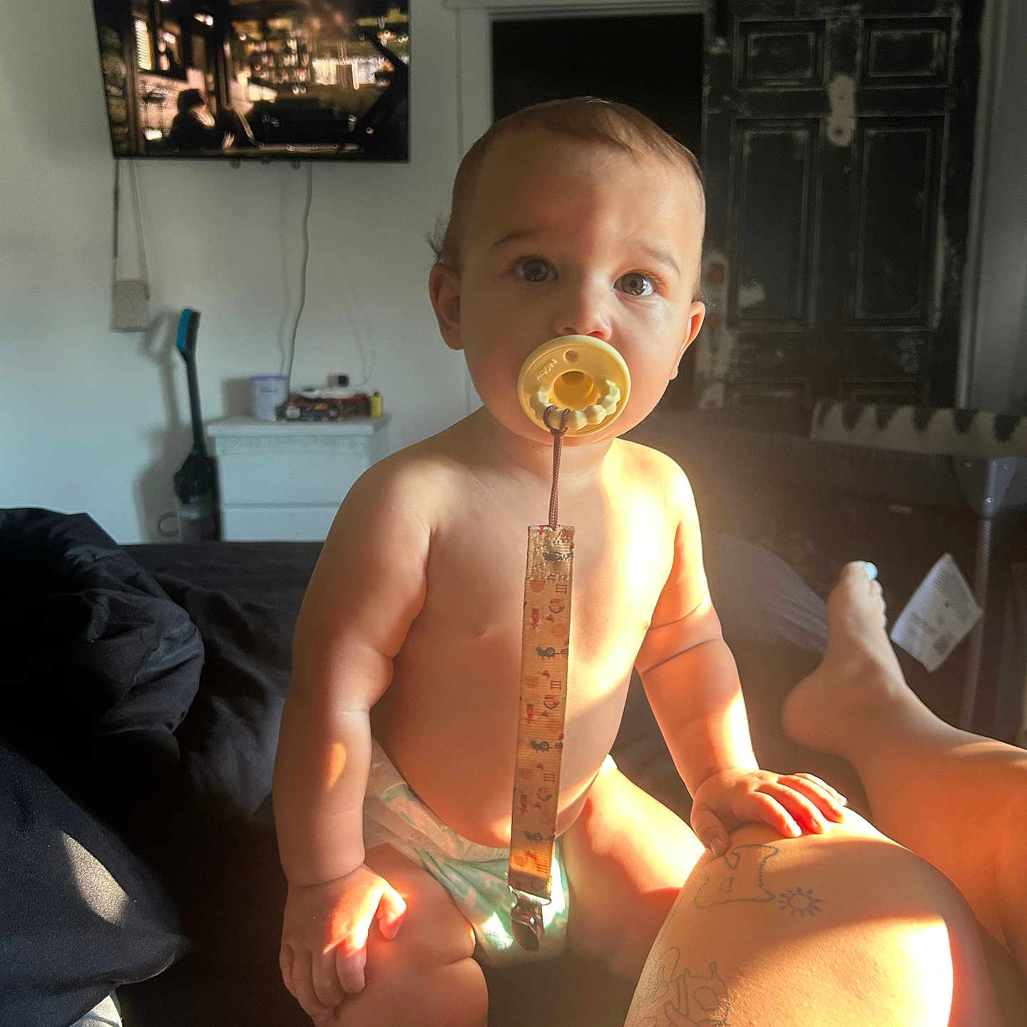 Caizyen joined the competition — help win amazing prizes! baby, pacifier, diaper, tattoo, leg, bed, sunlight, television, door, room, furniture, person, skin, indoor, tattooed_leg, child, curious, warm_light, relaxed, casual