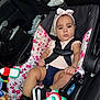 Allyson joined the competition — help win amazing prizes! baby, black, car_interior, car_seat, child, clothing, cute, floral_pattern, footwear, headband, infant, person, pink, safety, seatbelt, serious_expression, sitting, sneakers, toy, white