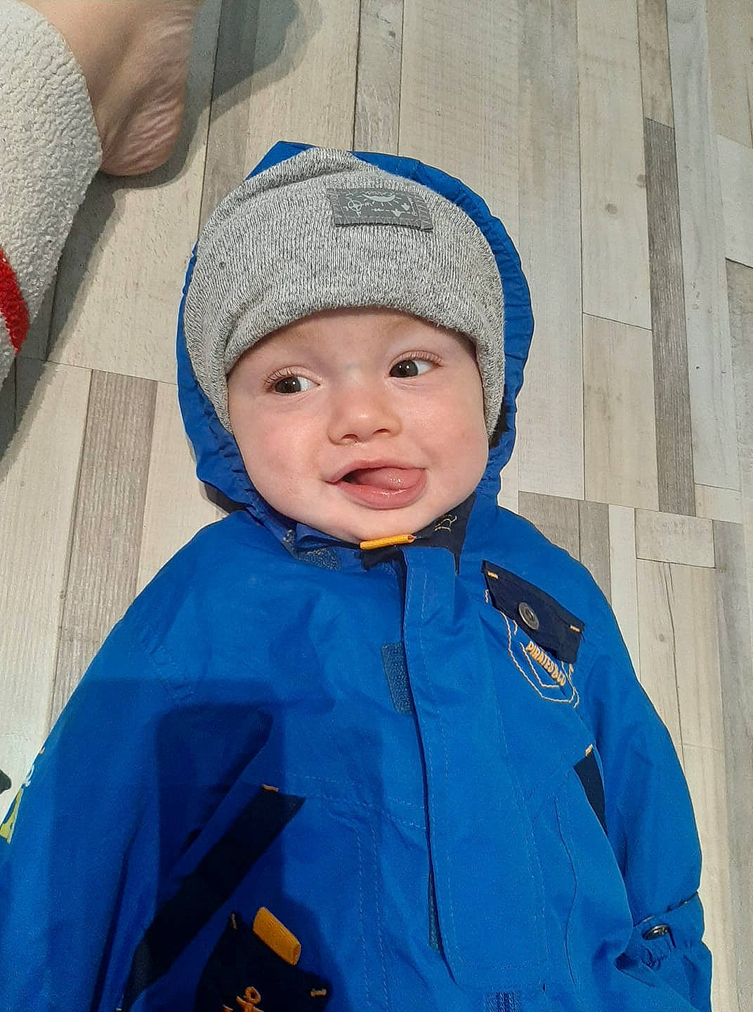 Nolan participe au concours pour gagner de l'argent avec cette photo : baby_toddler_clothing, beanie, cap, child, electric_blue, face, fashion_accessory, freezing, happy, hat, headwear, hood, knit_cap, outerwear, person, sleeve, smile, toddler, windbreaker, winter