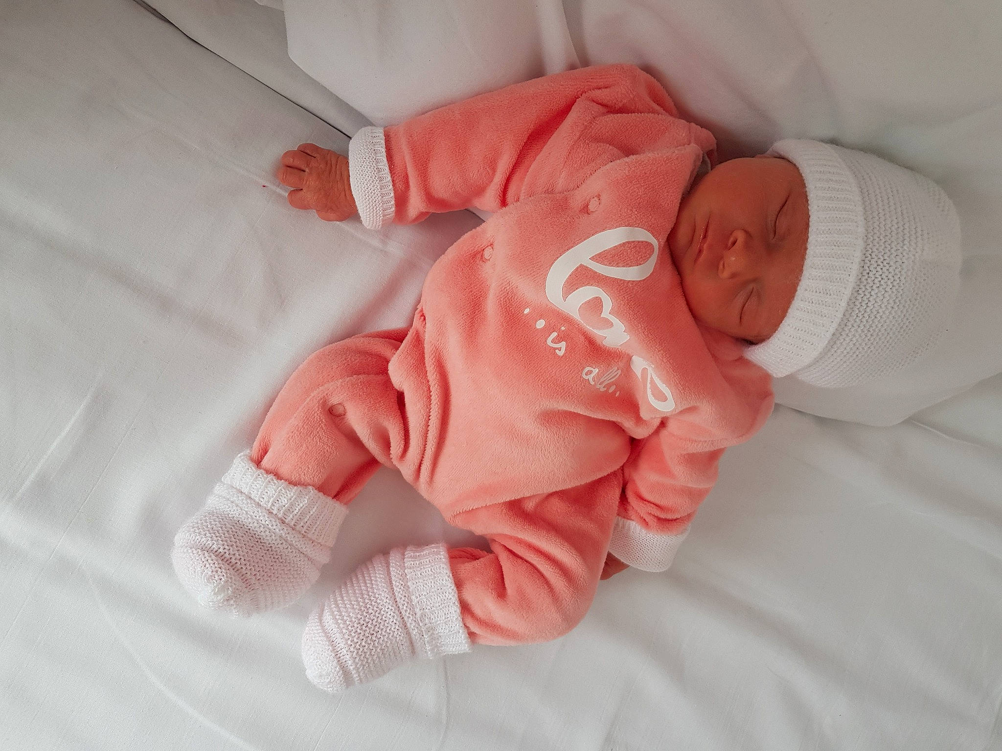 Alycia participe au concours pour gagner de l'argent avec cette photo : arm, baby, baby_products, baby_sleeping, baby_toddler_clothing, comfort, eye, face, finger, hand, head, headwear, human_body, linens, nail, peach, person, pink, sleeve, textile