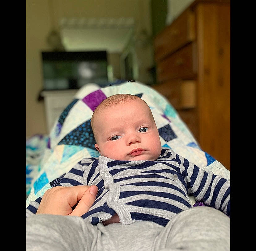 Wesley is registered to the contest to win money with this photo: baby, baby_toddler_clothing, beanie, cap, cheek, child, chin, collar, comfort, eye, face, flash_photography, happy, iris, linens, pattern, person, plaid, sitting, sleeve