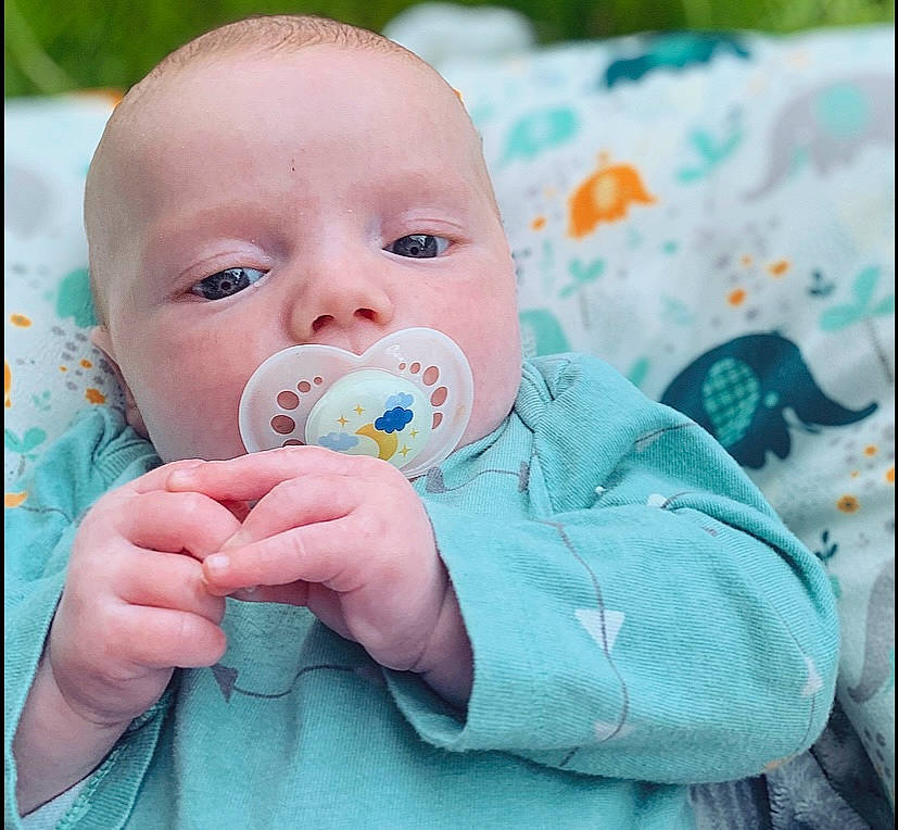 Wesley is registered to the contest to win money with this photo: aqua, baby, baby_products, baby_toddler_clothing, cheek, child, comfort, eyelash, finger, fun, gesture, grass, happy, iris, lip, nail, nose, pattern, people_in_nature, person