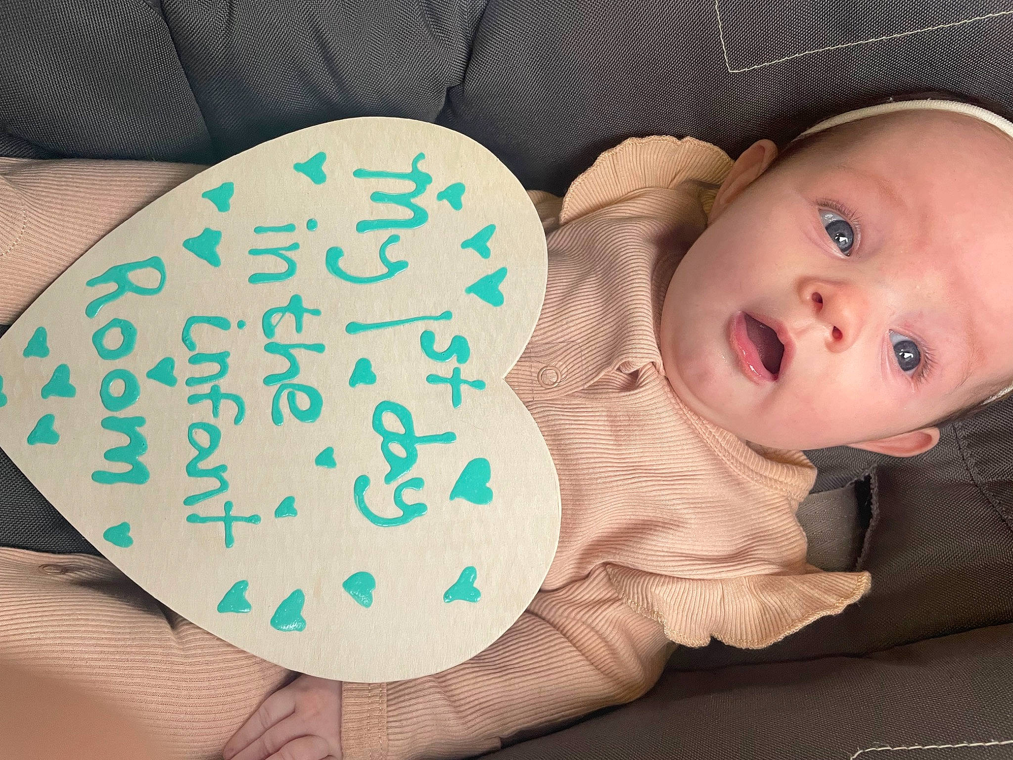 Delilah is registered to the contest to win money with this photo: arm, baby, baby_toddler_clothing, cheek, comfort, eyelash, facial_expression, finger, gesture, hand, happy, mammal, mouth, neck, organ, person, skin, sleeve, surprise, textile